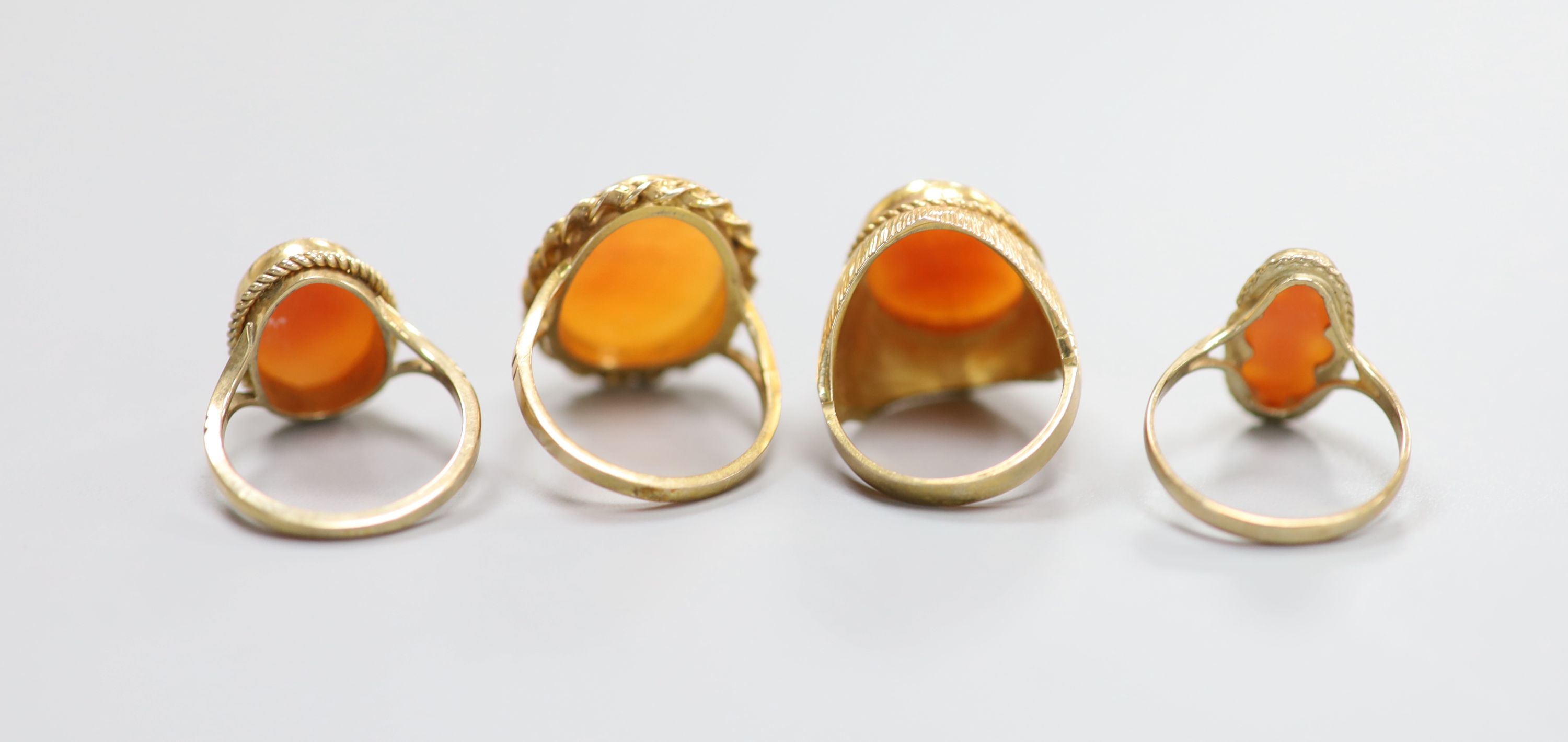 Four assorted modern 9ct and cameo shell dress rings including one carved with The Three Graces